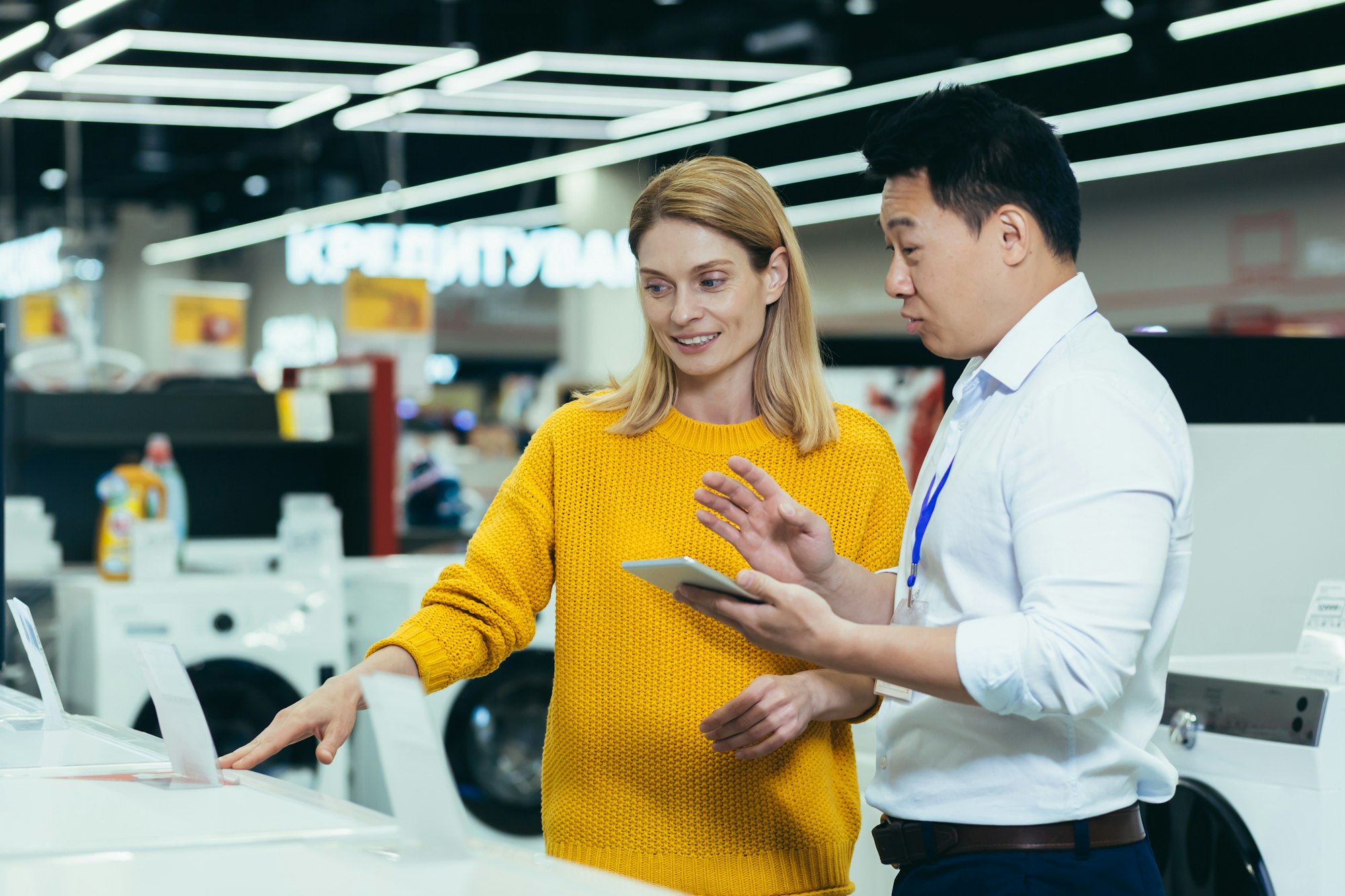 Asian consultant salesman in electronics and household appliances store, selling