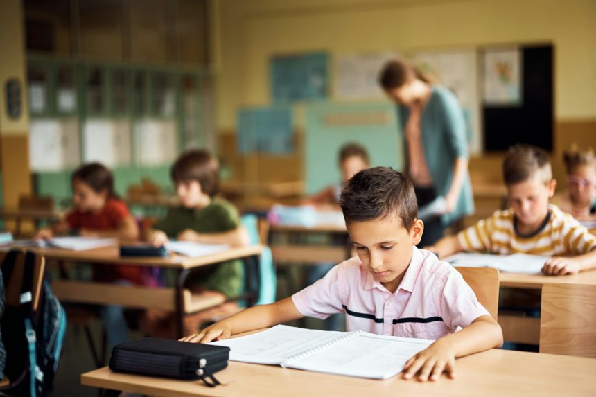 Elementary student learning in the classroom at school.