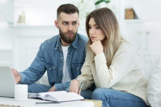 Worried family managing finances on laptop at home