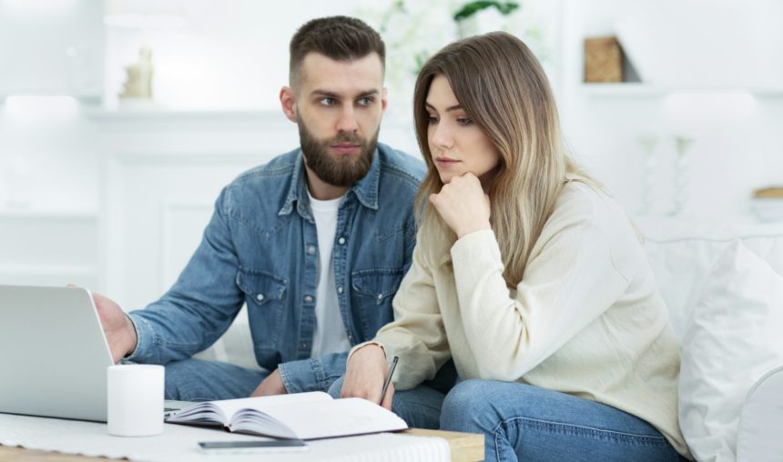 Worried family managing finances on laptop at home